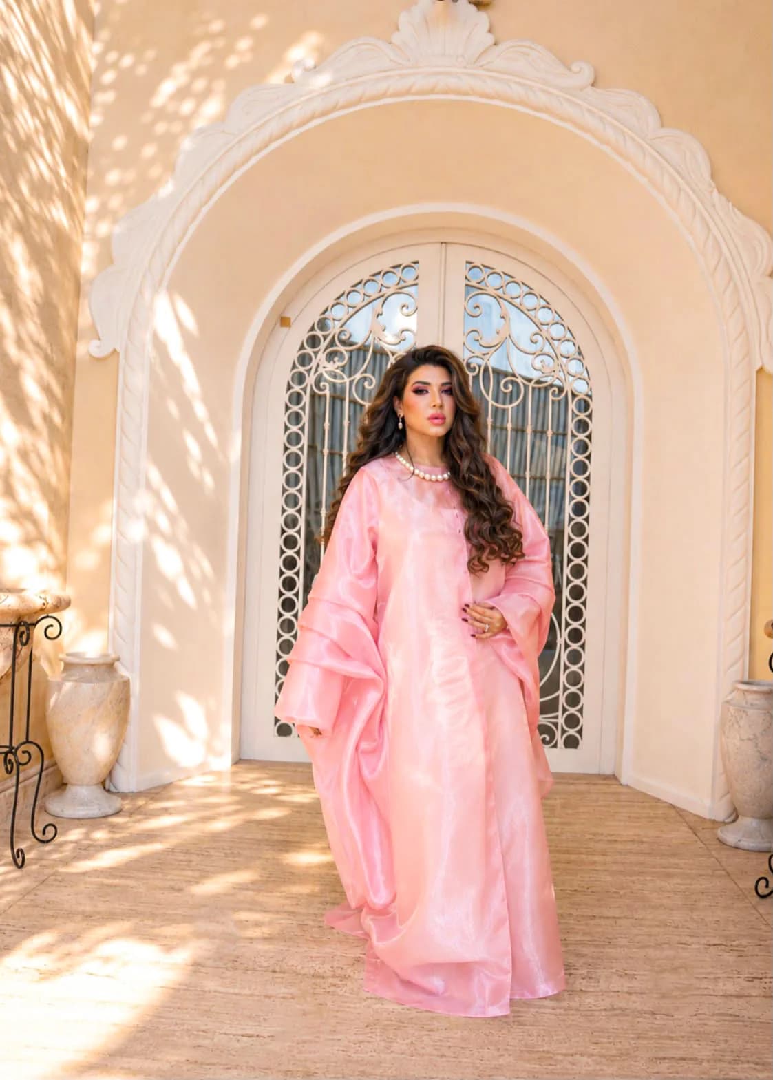 Almas Anfar Kathuria in a flowing pink look at an ornate doorway